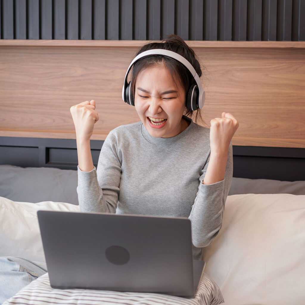 asian-woman-with-headphone-raising-hands-after-rec-2022-11-15-15-36-13-utc