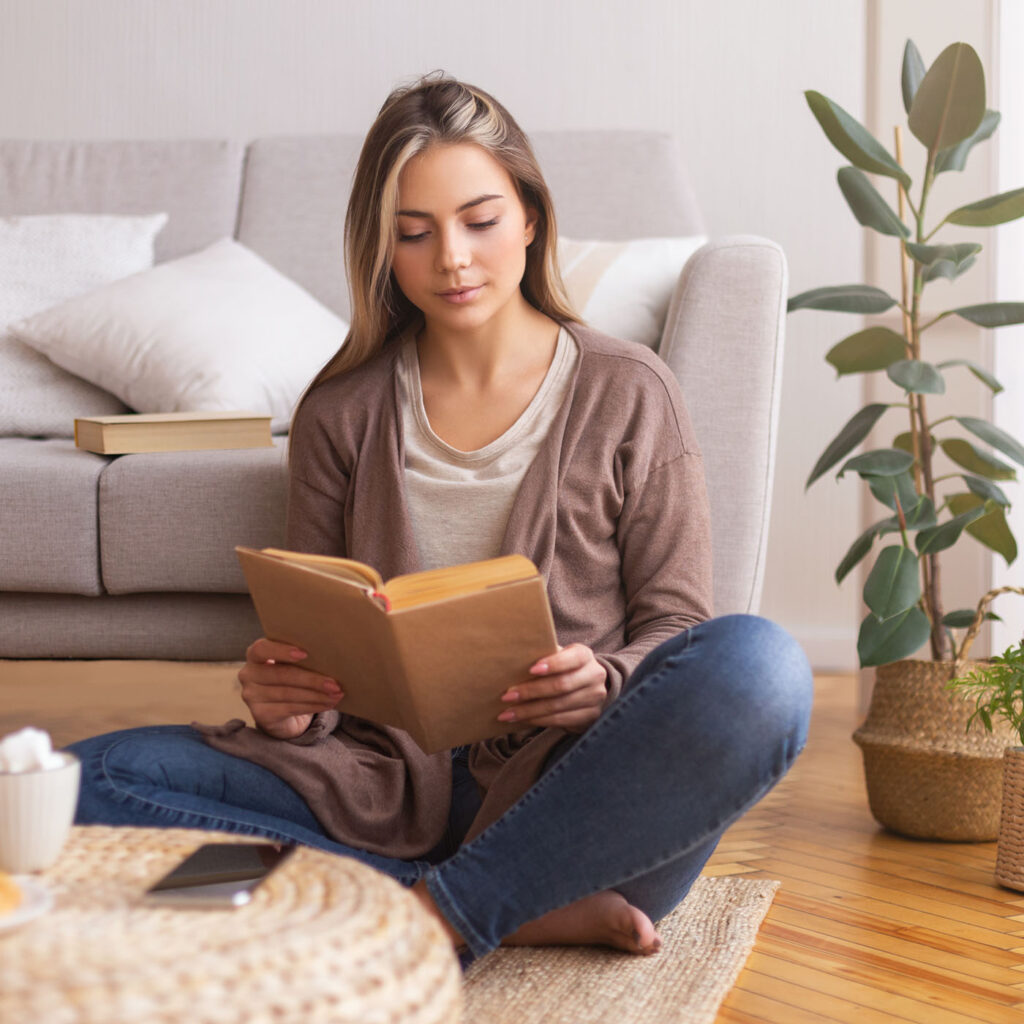 beautiful-young-woman-reading-book-on-floor-2022-12-16-09-23-59-utc